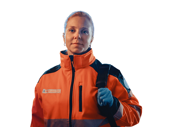 A woman smiling to camera. She is wearing a thick jacket and gloves