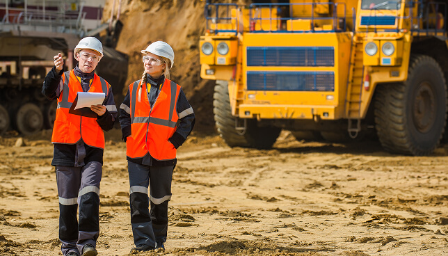 Male and female mine workers standing together