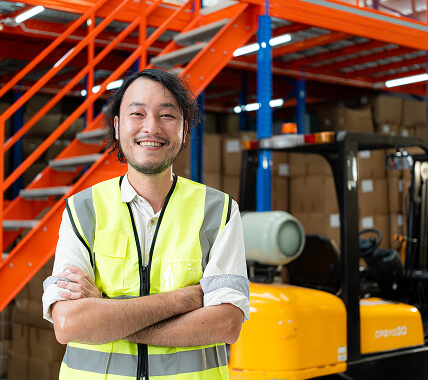 A man in a warehouse smiling to camera